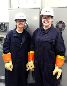 Haley Hughes (right) and Kristen Sabino stand in the meter training room at an NStar learning facility. The two are part of an apprenticeship program with the utility company, something economists say the U.S. needs more of in order to fill open trade jobs. Courtesy of Earl Benders