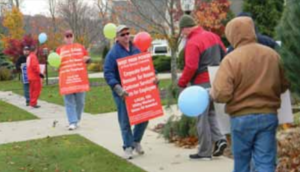 FirstEnergy President and Chief Executive Officer Tony Alexander could not escape from UWUA members demonstrating at his home, pictured here contrasting his multi-million dollar salary with their own